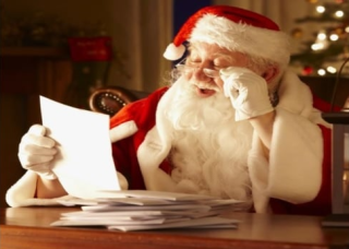 Image of Santa sitting at a desk, reading a letter