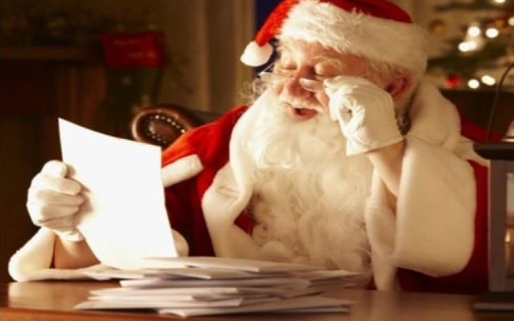 Image of Santa sitting at a desk, reading a letter